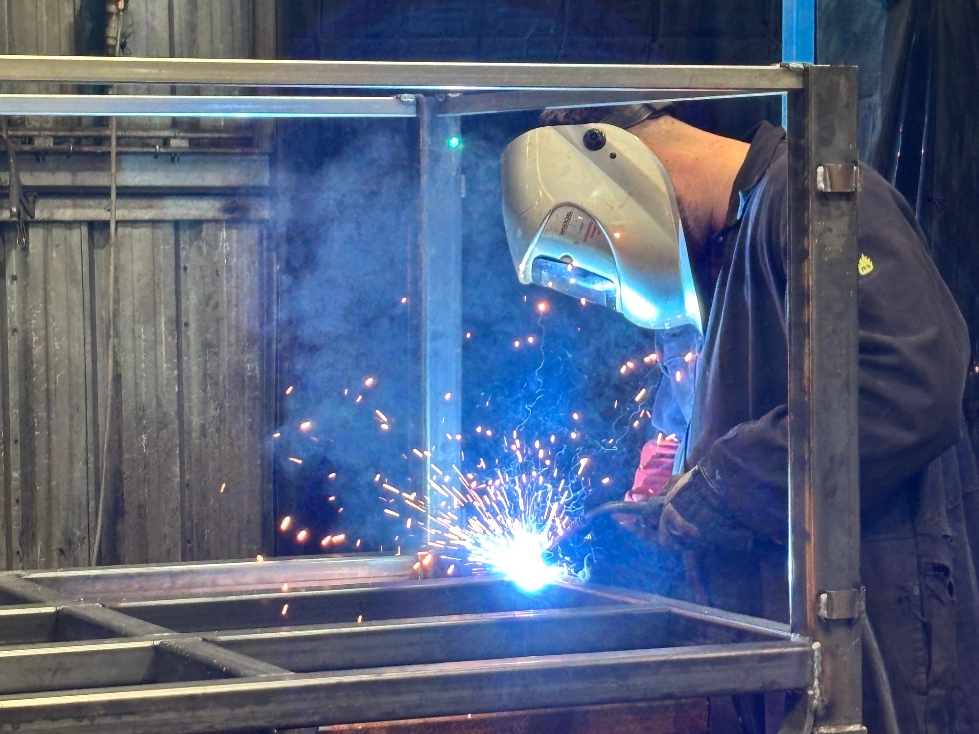 Welder repairing a steel frame in the Bache Pallets workshop
