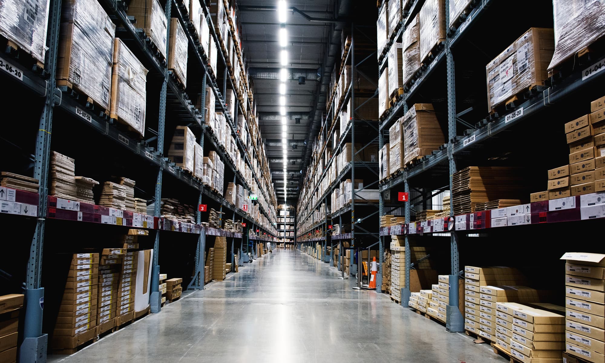 Pallet racking lining a warehouse aisle with boxed stock on both sides